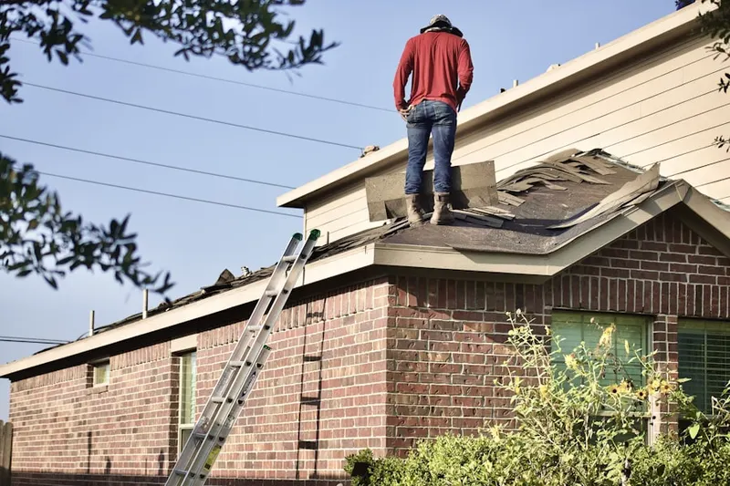 Professional roofer working on a residential roof in Comstock